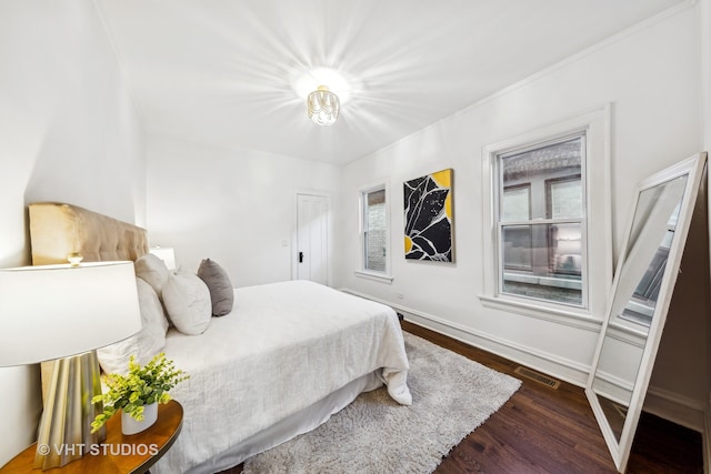 bedroom featuring crown molding and dark hardwood / wood-style floors