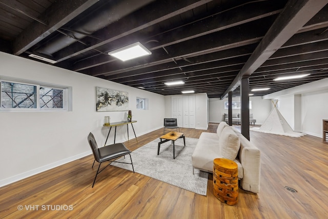 living room featuring beam ceiling and hardwood / wood-style flooring