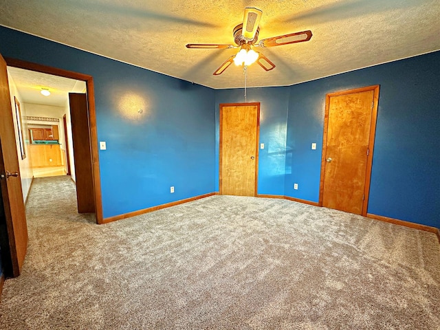 unfurnished bedroom featuring carpet, a textured ceiling, and ceiling fan