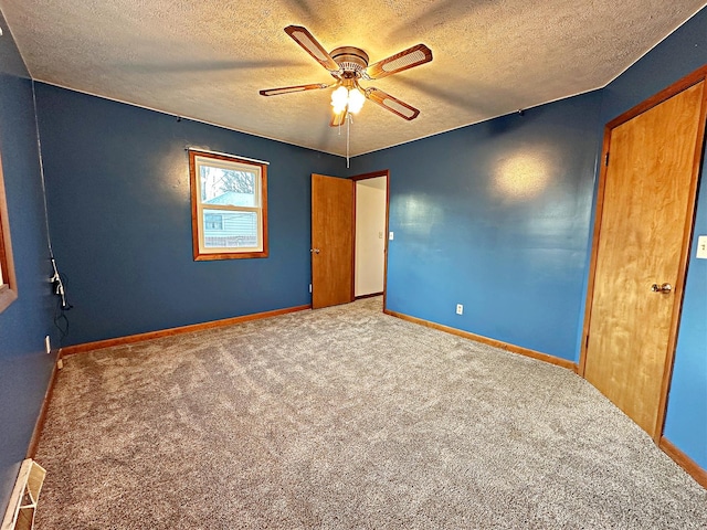 unfurnished bedroom with a textured ceiling, carpet floors, and ceiling fan