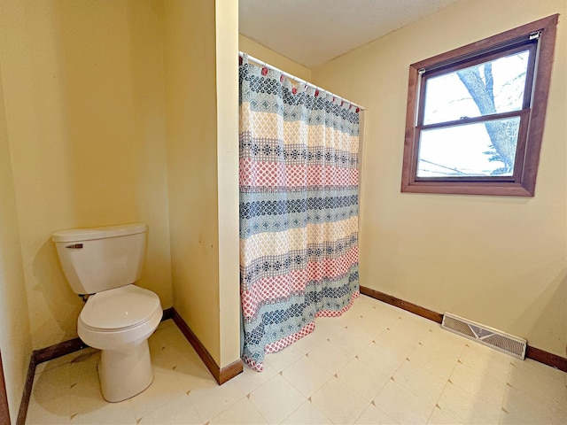 bathroom with a shower with curtain and toilet