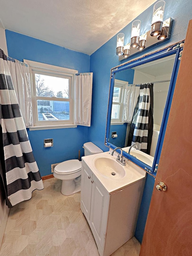 bathroom featuring vanity, a textured ceiling, and toilet