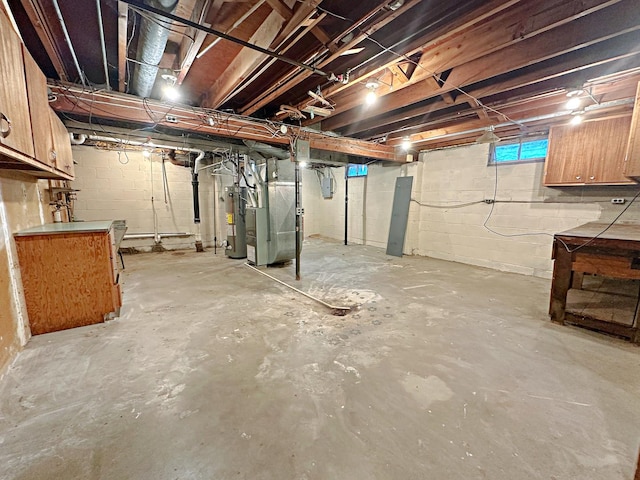 basement with electric panel, gas water heater, and heating unit