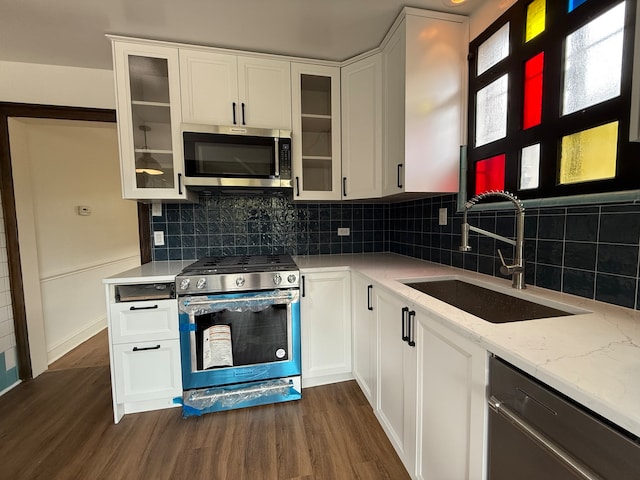 kitchen featuring dark hardwood / wood-style flooring, white cabinetry, sink, and appliances with stainless steel finishes