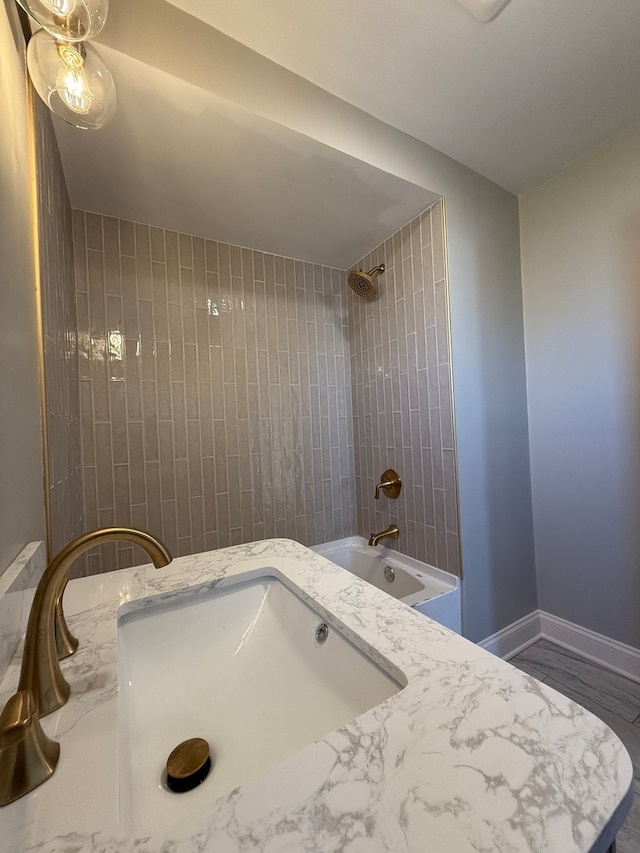 bathroom with sink and tiled shower / bath