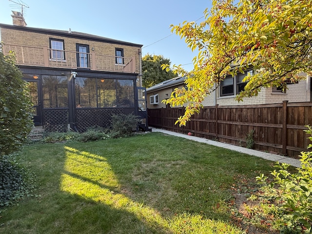 view of yard featuring a balcony and a sunroom