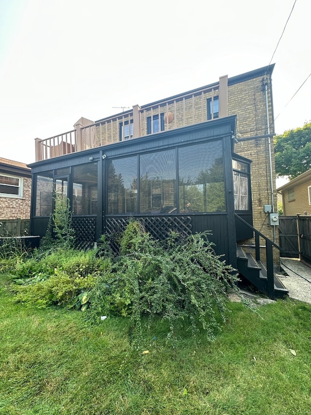 rear view of house featuring a sunroom