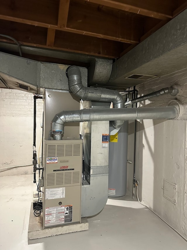 utility room featuring gas water heater and heating unit