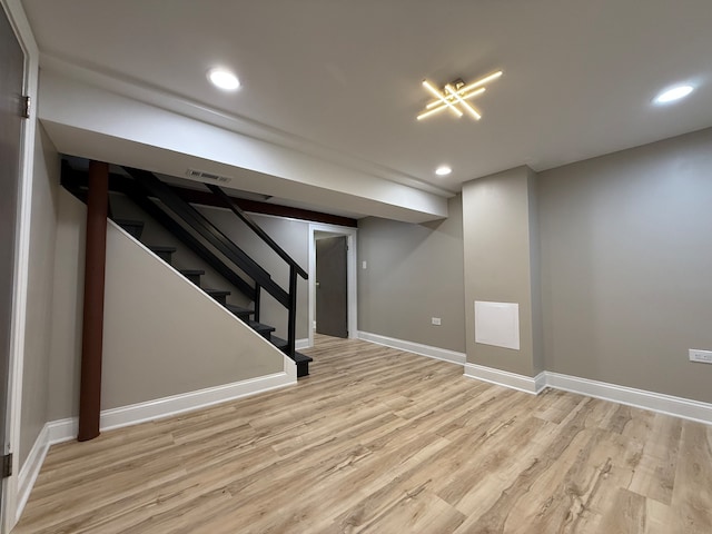 basement with light hardwood / wood-style flooring