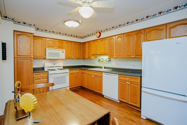 kitchen featuring white appliances, light hardwood / wood-style floors, ceiling fan, and sink