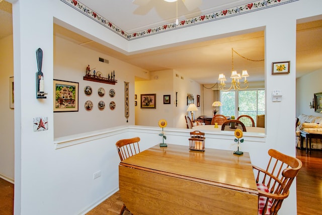 dining room with ceiling fan with notable chandelier and wood-type flooring