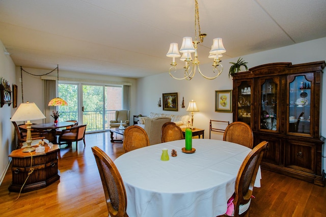 dining space featuring hardwood / wood-style floors and a chandelier