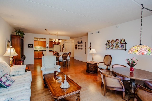 living room featuring light hardwood / wood-style floors and a notable chandelier