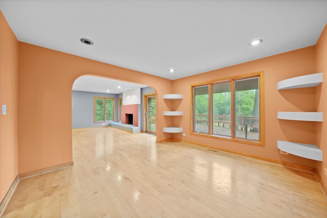 unfurnished living room with plenty of natural light and light hardwood / wood-style flooring