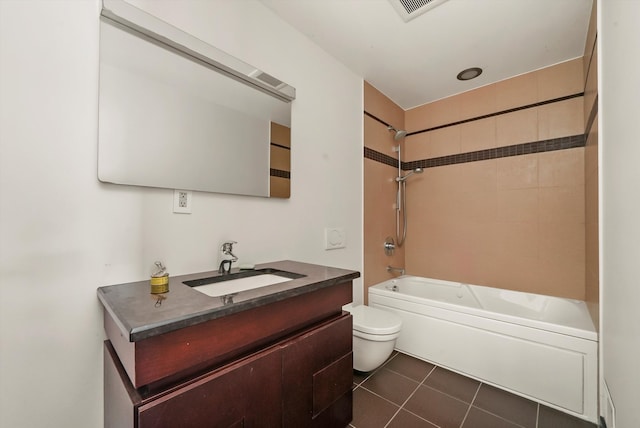 full bathroom with tile patterned floors, vanity, tiled shower / bath combo, and toilet