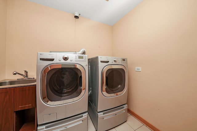 washroom with light tile patterned flooring, cabinets, separate washer and dryer, and sink