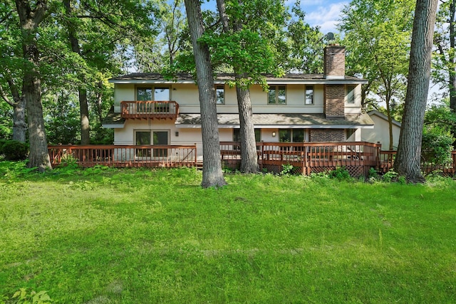 back of house featuring a balcony, a yard, and a deck