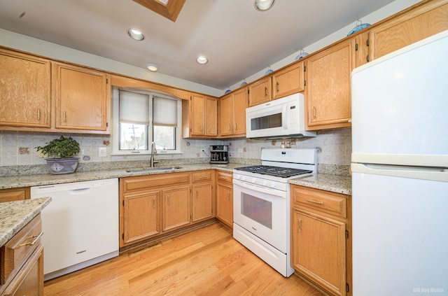 kitchen featuring white appliances, backsplash, sink, light hardwood / wood-style floors, and light stone counters