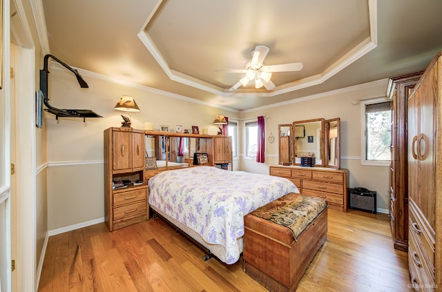 bedroom with light hardwood / wood-style floors, a raised ceiling, ceiling fan, and ornamental molding