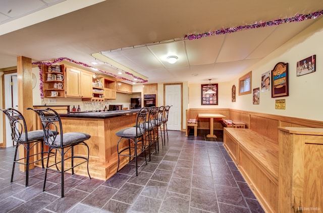 bar with oven, light brown cabinetry, and track lighting