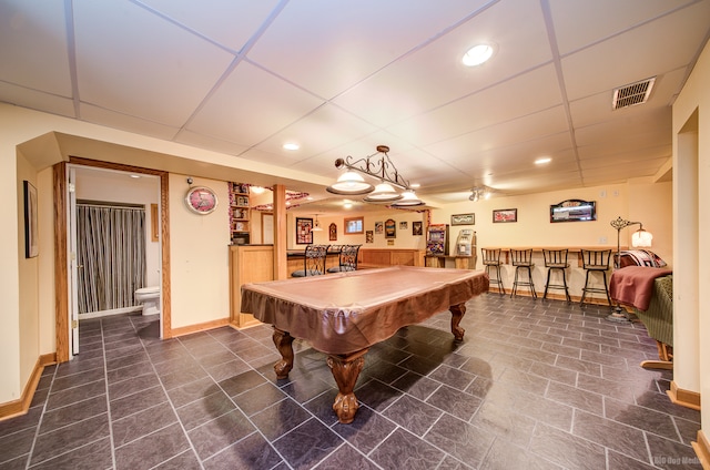 recreation room featuring a drop ceiling, bar, and pool table