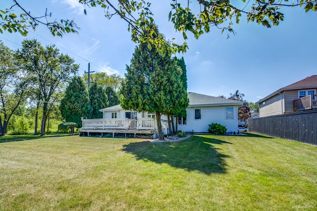 rear view of property featuring a lawn and a deck