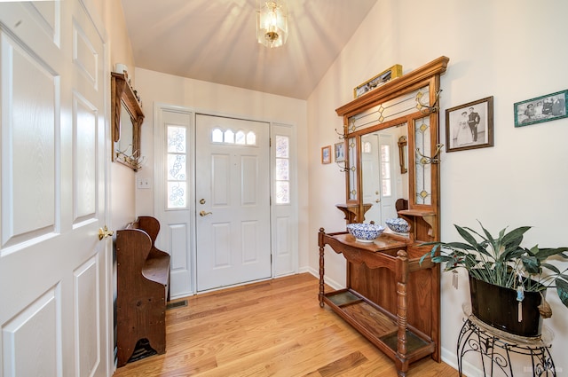 foyer entrance with light hardwood / wood-style floors and lofted ceiling