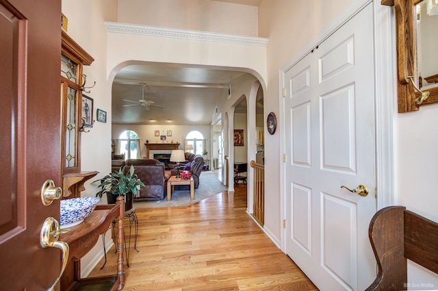 entrance foyer featuring ceiling fan, light hardwood / wood-style floors, and crown molding