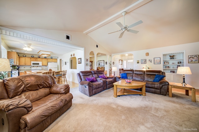 carpeted living room featuring beam ceiling, built in shelves, ceiling fan, and high vaulted ceiling