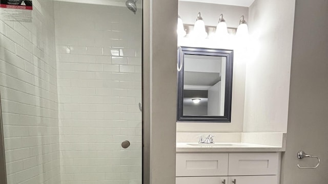 bathroom with a tile shower and vanity