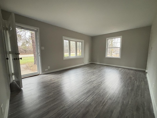 spare room featuring dark hardwood / wood-style floors and a healthy amount of sunlight