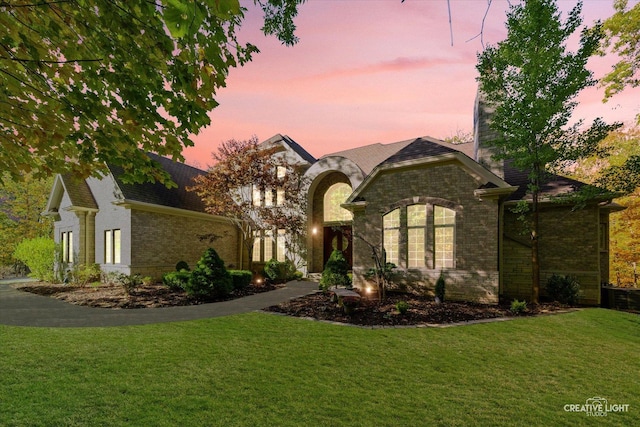 french provincial home with a lawn