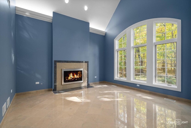 unfurnished living room featuring a towering ceiling and a premium fireplace