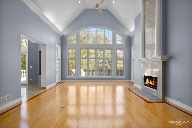 unfurnished living room with a fireplace, light hardwood / wood-style floors, ceiling fan, and a healthy amount of sunlight