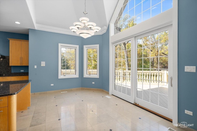 unfurnished dining area featuring light tile patterned floors, crown molding, and a chandelier