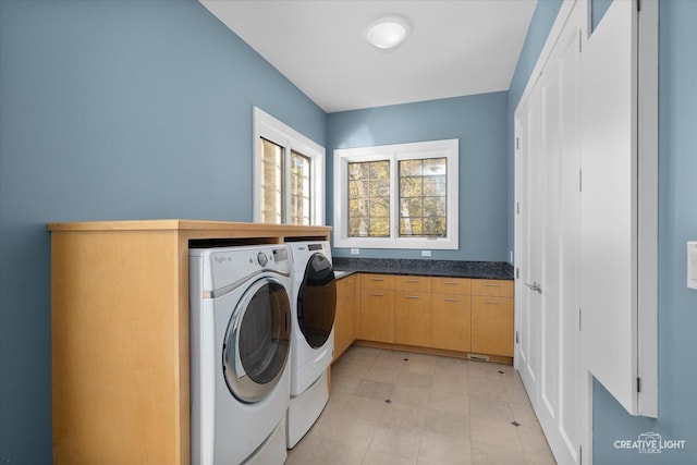 washroom with washer and dryer and cabinets