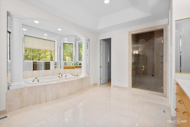 bathroom with decorative columns, tile patterned floors, vanity, a tray ceiling, and shower with separate bathtub