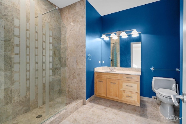 bathroom with tiled shower, vanity, and toilet