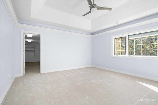 interior space featuring a tray ceiling, crown molding, ceiling fan, and light colored carpet