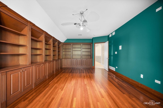 interior space featuring wood-type flooring, built in features, ceiling fan, and lofted ceiling