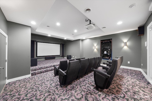 carpeted home theater with a raised ceiling