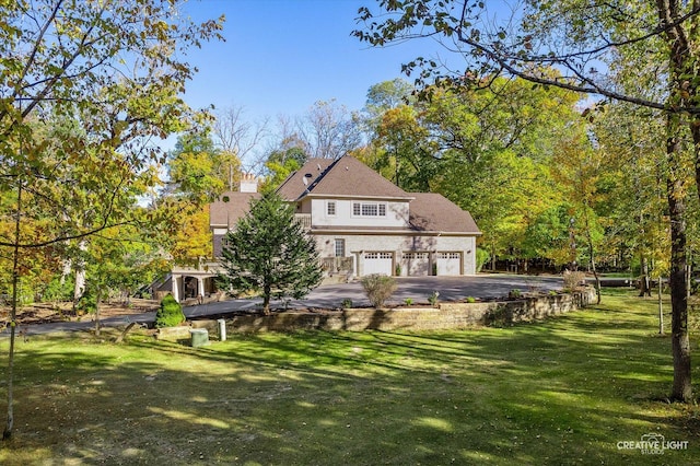 rear view of property featuring a garage and a yard