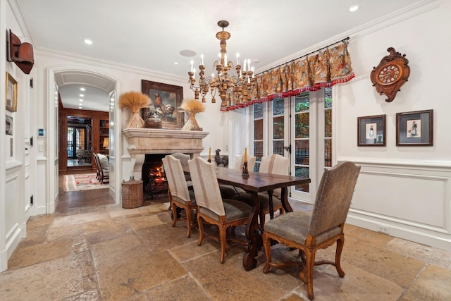 dining space featuring french doors, crown molding, and a chandelier