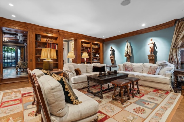 living room featuring light hardwood / wood-style flooring, built in features, and ornamental molding