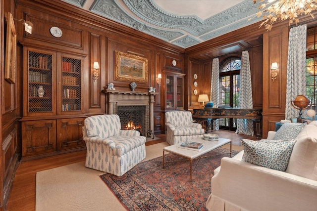 sitting room featuring hardwood / wood-style flooring, crown molding, plenty of natural light, and wooden walls