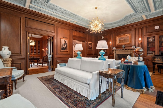 interior space with crown molding, light hardwood / wood-style flooring, wooden walls, and an inviting chandelier