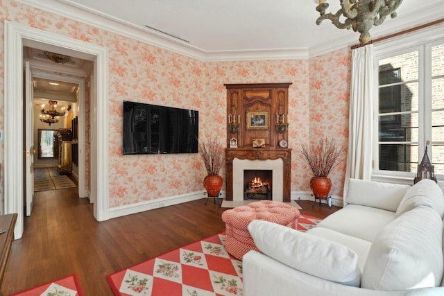 living room with dark hardwood / wood-style flooring, crown molding, and a chandelier