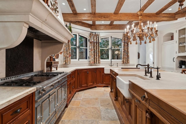 kitchen featuring beam ceiling, sink, hanging light fixtures, and stainless steel gas stovetop