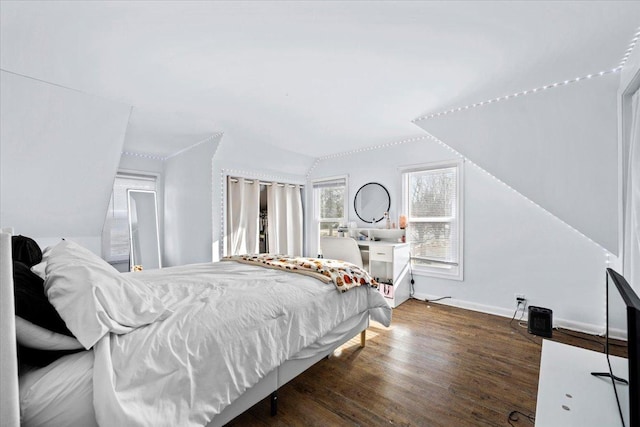 bedroom featuring dark wood-type flooring and vaulted ceiling