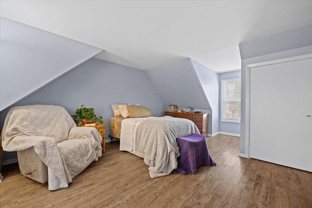 bedroom featuring wood-type flooring and lofted ceiling